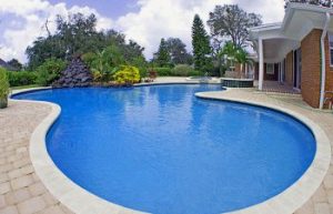 Large backyard swimming pool with clear blue water.