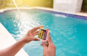 A person testing the chlorine and PH of swimming pool.