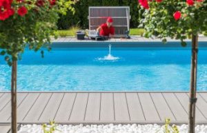 Professional technician performing outdoor swimming pool check up and repair.
